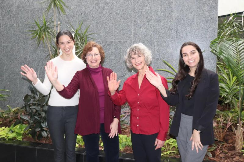 four women waving